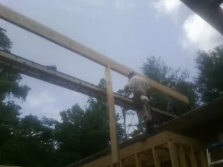 Carpenter setting a ridge beam over a new addition frame — Ice Dam Removal by Roofing Brothers in Mountville