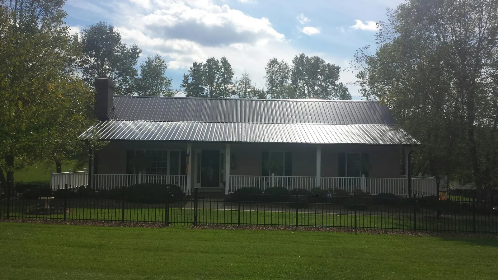 Gray metal roof on a brick ranch with a full width front porch — Gutter Guard Installation work by our crew in Mountville