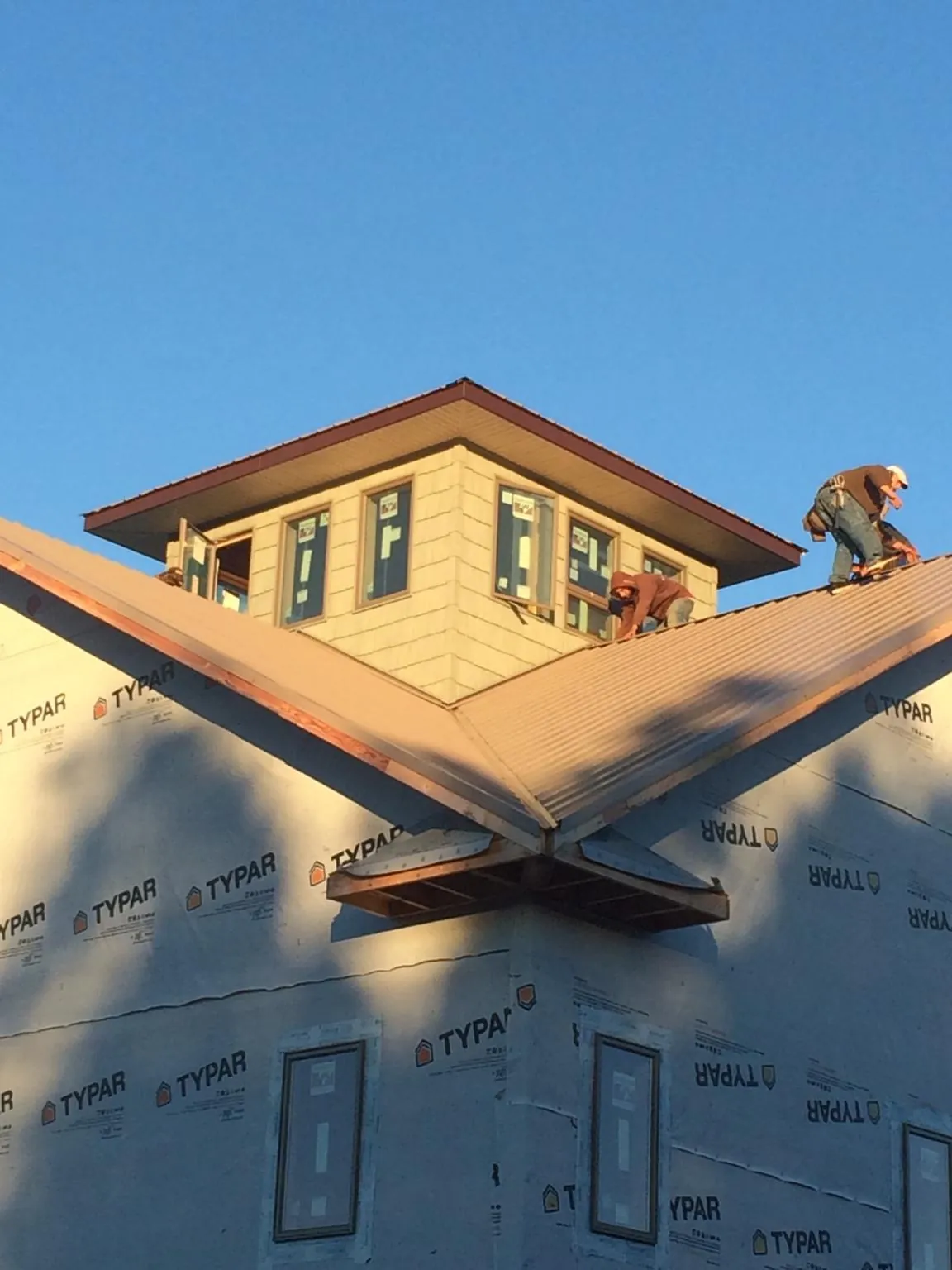Roofers working around a rooftop cupola on a new metal roof at sunset — Roof Waterproofing in Mountville by Roofing Brothers
